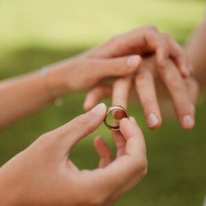 A beautiful close-up of two individuals exchanging wedding rings, symbolizing love and commitment.